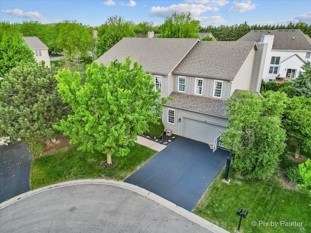 9 Laurel Valley Ct, Lake In The Hills, IL 60156 - view of front of house with a chimney, driveway, an attached garage, a shingled roof, and a front yard