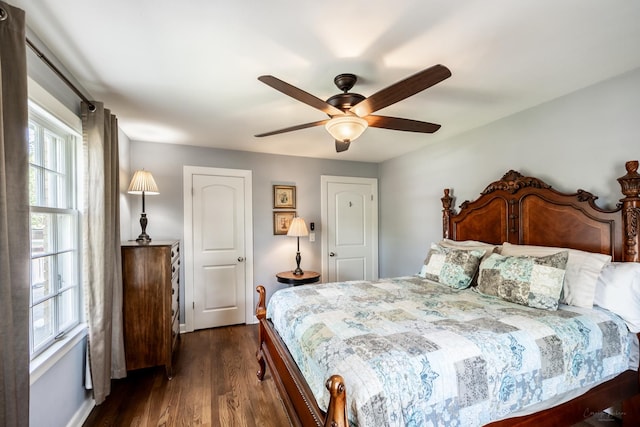 bedroom with dark wood-style flooring, ceiling fan, and baseboards