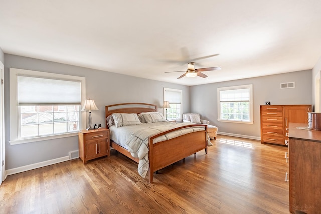bedroom with wood finished floors, baseboards, and a ceiling fan