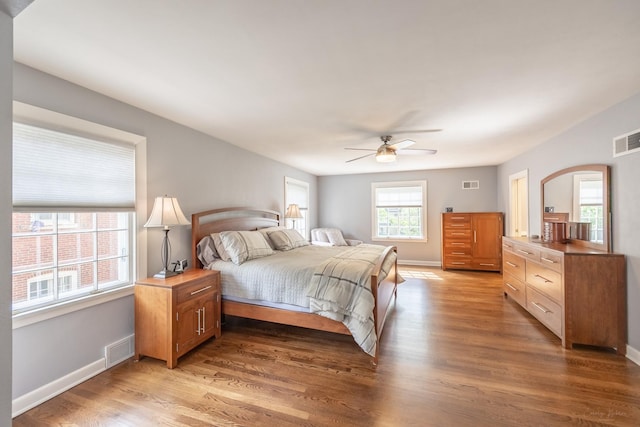 bedroom featuring light wood-style flooring, arched walkways, baseboards, and ceiling fan