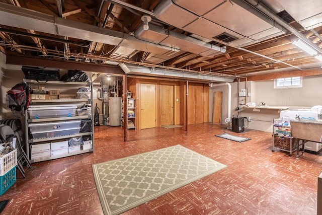 basement with tile patterned floors and gas water heater