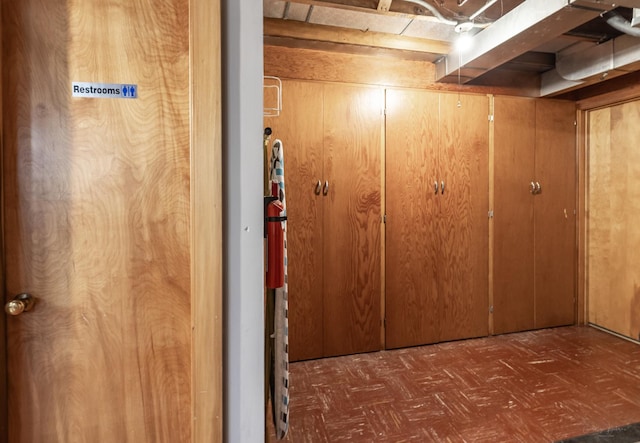 below grade area with tile patterned floors and wooden walls