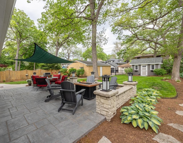 view of patio / terrace featuring an outdoor fire pit and an outbuilding