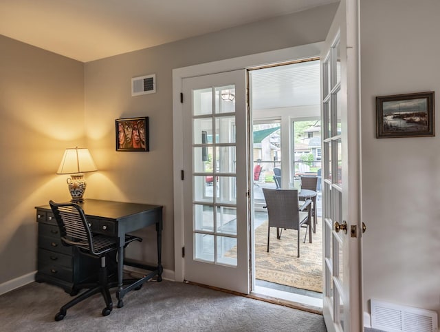 doorway featuring baseboards and carpet flooring