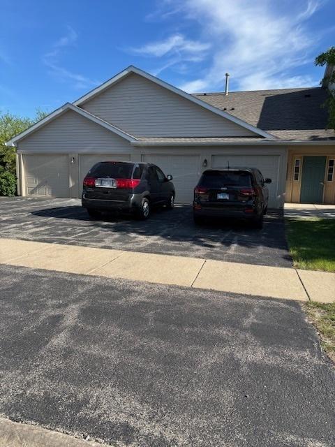 1286 N Red Oak Cir Unit 4, Round Lake Beach, IL 60073 - view of property exterior with asphalt driveway, an attached garage, and a shingled roof
