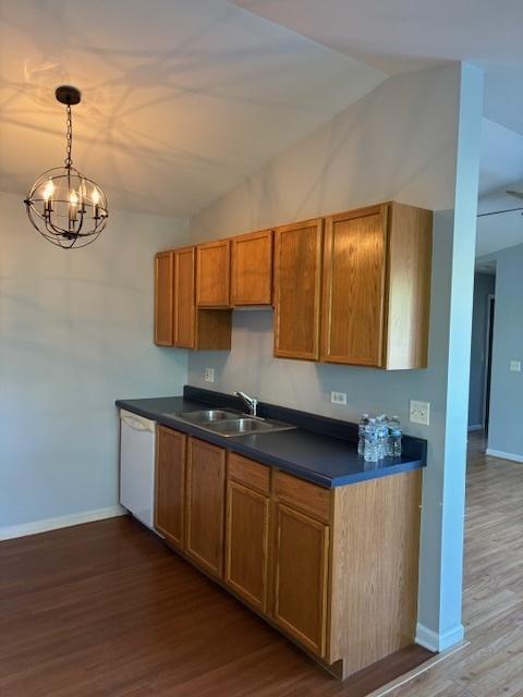 1286 N Red Oak Cir Unit 4, Round Lake Beach, IL 60073 - kitchen featuring a sink, dark countertops, wood finished floors, white dishwasher, and a chandelier