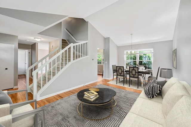 1400 Carleton Ave, Naperville, IL 60565 - living room featuring stairway, wood finished floors, a chandelier, baseboards, and lofted ceiling