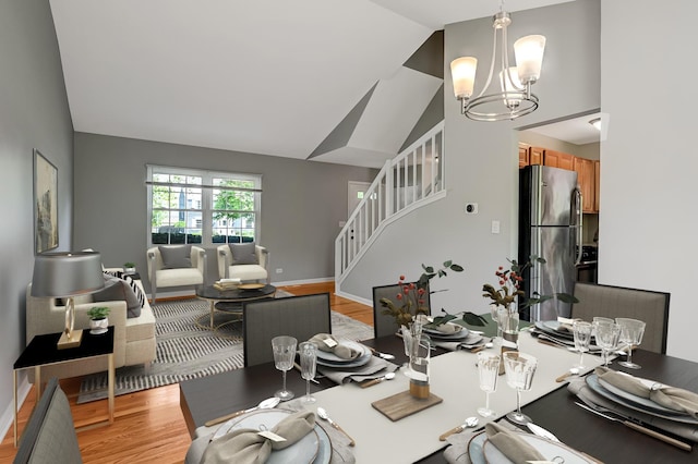 1400 Carleton Ave, Naperville, IL 60565 - dining room featuring a chandelier, high vaulted ceiling, stairs, light wood-style floors, and baseboards