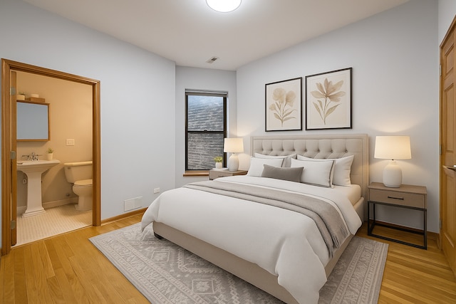 6137 S Kimbark Ave Unit 1, Chicago, IL 60637 - bedroom featuring light wood-type flooring, ensuite bath, baseboards, and a sink