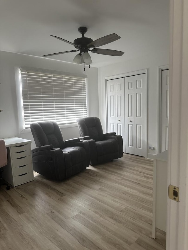 living room with ceiling fan and light wood-style flooring