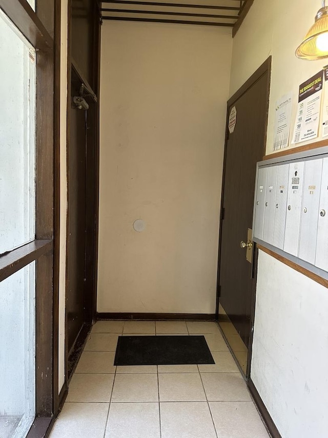 corridor with mail area and light tile patterned flooring