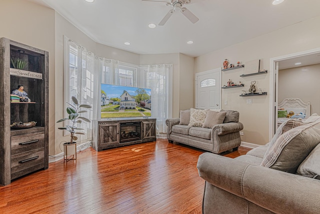 living room with ceiling fan, wood finished floors, baseboards, and recessed lighting