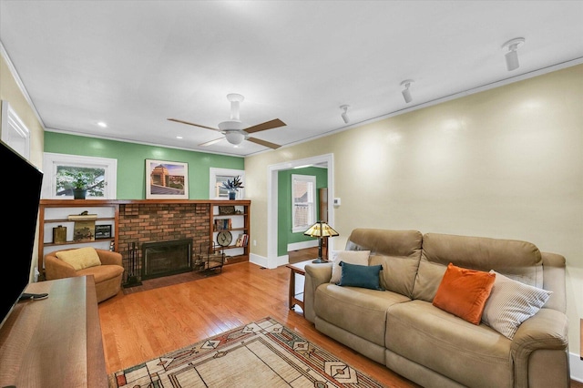 606 S Cedar St, Urbana, IL 61801 - living room featuring wood finished floors, crown molding, a ceiling fan, a brick fireplace, and baseboards