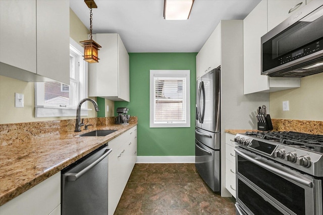 606 S Cedar St, Urbana, IL 61801 - kitchen with appliances with stainless steel finishes, a sink, white cabinetry, baseboards, and light stone countertops