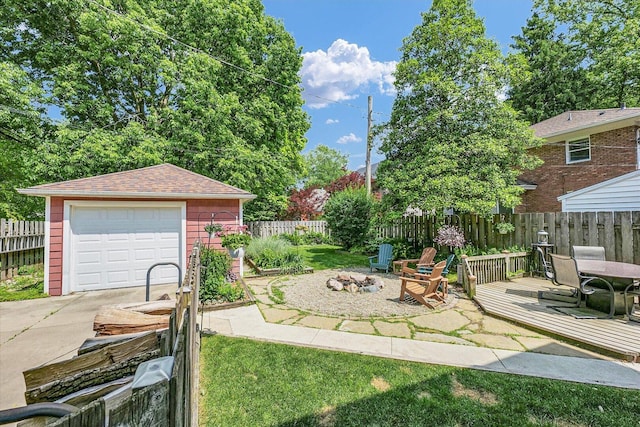 606 S Cedar St, Urbana, IL 61801 - view of yard featuring concrete driveway, an outdoor structure, an outdoor fire pit, a garage, and a deck