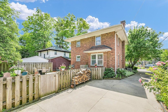 606 S Cedar St, Urbana, IL 61801 - view of front of house with brick siding, a patio area, and a chimney