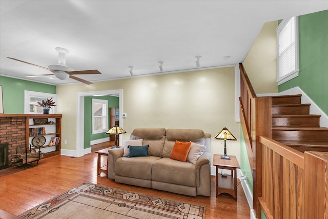 606 S Cedar St, Urbana, IL 61801 - living area with wood finished floors, stairway, ceiling fan, a brick fireplace, and baseboards