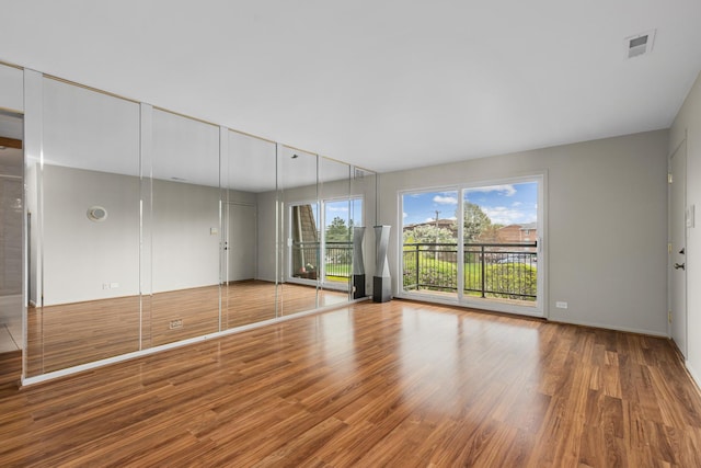 unfurnished living room featuring wood finished floors and baseboards