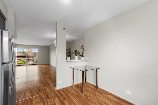 hallway with wood finished floors and baseboards