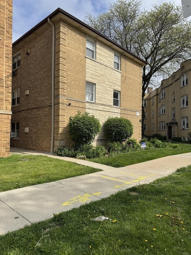 4456 W Gunnison St Unit 2A, Chicago, IL 60630 - view of side of property featuring brick siding and a yard