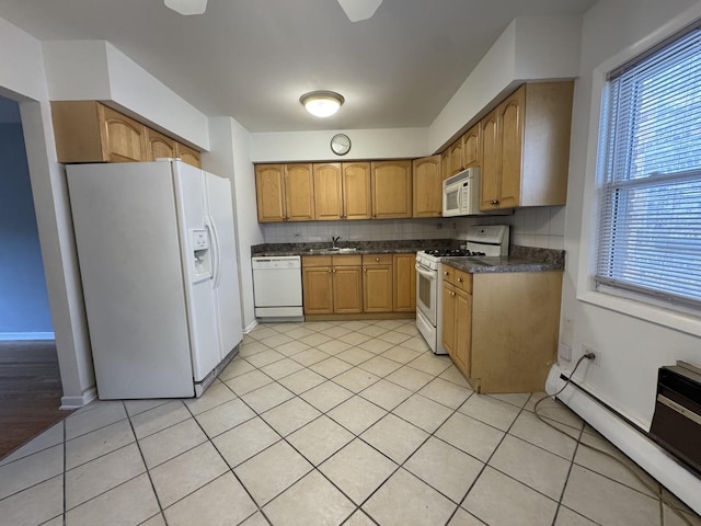 4456 W Gunnison St Unit 2A, Chicago, IL 60630 - kitchen featuring white appliances, a sink, dark countertops, a baseboard radiator, and light tile patterned flooring