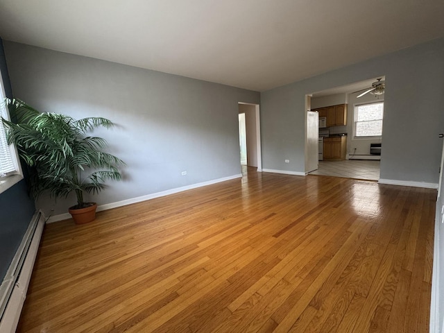 4456 W Gunnison St Unit 2A, Chicago, IL 60630 - empty room with a baseboard radiator, light wood-type flooring, ceiling fan, and baseboards