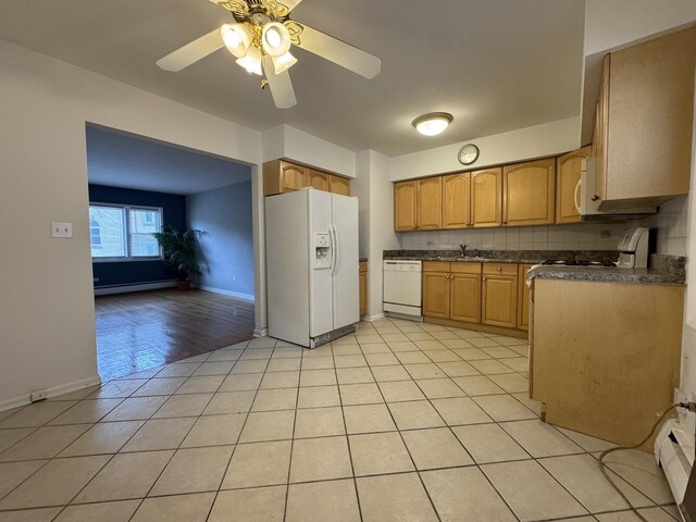 4456 W Gunnison St Unit 2A, Chicago, IL 60630 - kitchen with white appliances, baseboard heating, dark countertops, a sink, and ceiling fan