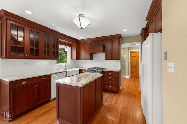 1532 Chat Ct, Naperville, IL 60565 - kitchen with white appliances, custom exhaust hood, light wood finished floors, a kitchen island, and glass insert cabinets