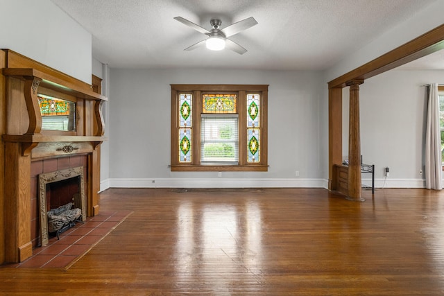 201 E Court St, Paris, IL 61944 - unfurnished living room featuring wood finished floors, ceiling fan, a tile fireplace, a textured ceiling, and baseboards
