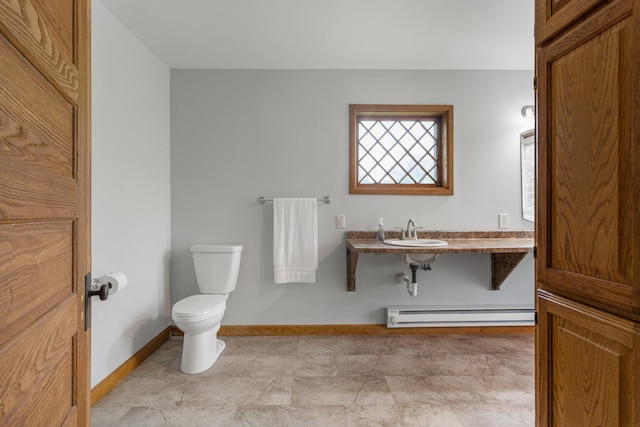 201 E Court St, Paris, IL 61944 - half bath with a baseboard heating unit, toilet, a sink, and baseboards