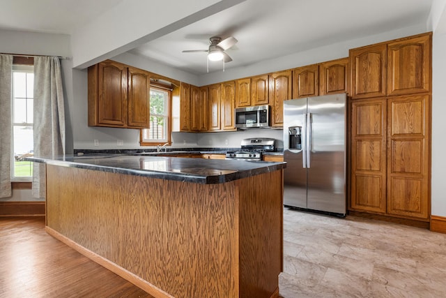 201 E Court St, Paris, IL 61944 - kitchen with stainless steel appliances, brown cabinetry, healthy amount of natural light, and ceiling fan