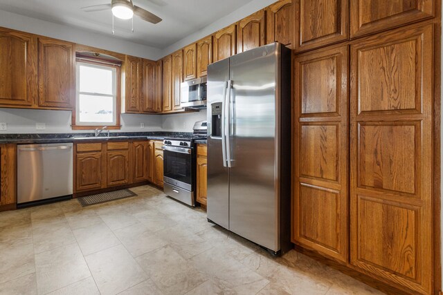 201 E Court St, Paris, IL 61944 - kitchen with stainless steel appliances, brown cabinetry, dark countertops, and ceiling fan