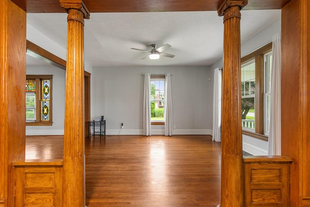 201 E Court St, Paris, IL 61944 - spare room featuring decorative columns, a ceiling fan, wood finished floors, baseboards, and a textured ceiling