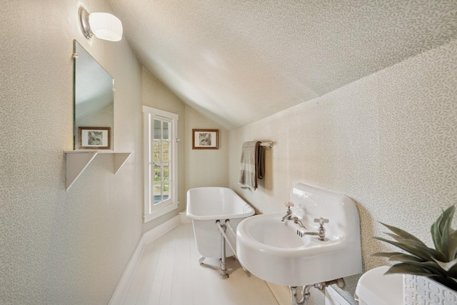 1557 Green Bay Rd, Highland Park, IL 60035 - bathroom featuring lofted ceiling, a sink, wood finished floors, and a textured ceiling