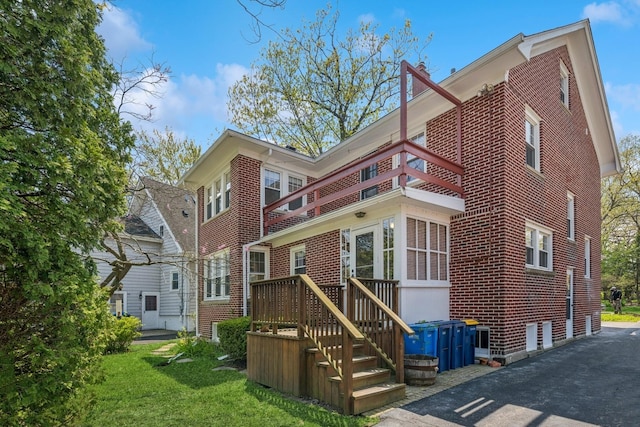 1557 Green Bay Rd, Highland Park, IL 60035 - rear view of house with a balcony, brick siding, and a lawn