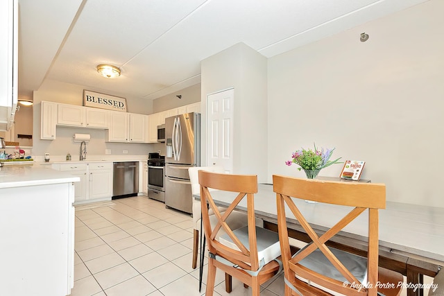 390 W Mahogany Ct Unit 301, Palatine, IL 60067 - kitchen featuring stainless steel appliances, light countertops, light tile patterned flooring, a sink, and white cabinets