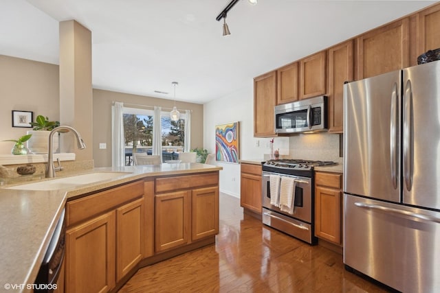 15130 Laurel Ln, Lockport, IL 60441 - kitchen featuring stainless steel appliances, a sink, light wood finished floors, brown cabinetry, and light countertops