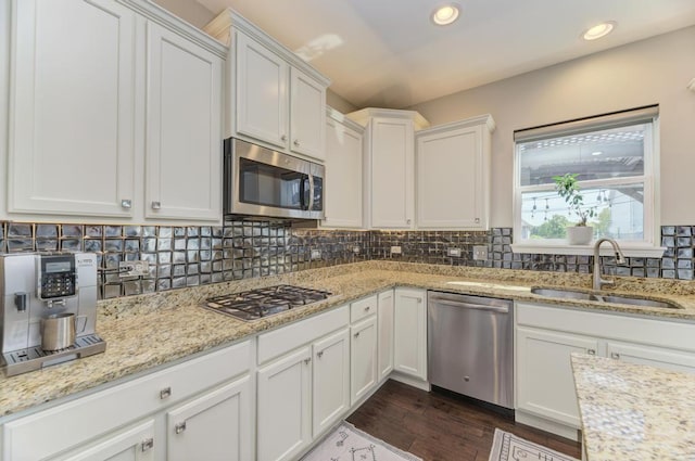 141 Bluegrass Pkwy, Oswego, IL 60543 - kitchen featuring appliances with stainless steel finishes, a sink, white cabinets, dark wood-style floors, and backsplash