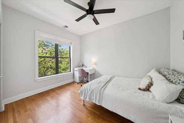 bedroom featuring baseboards, wood finished floors, and ceiling fan