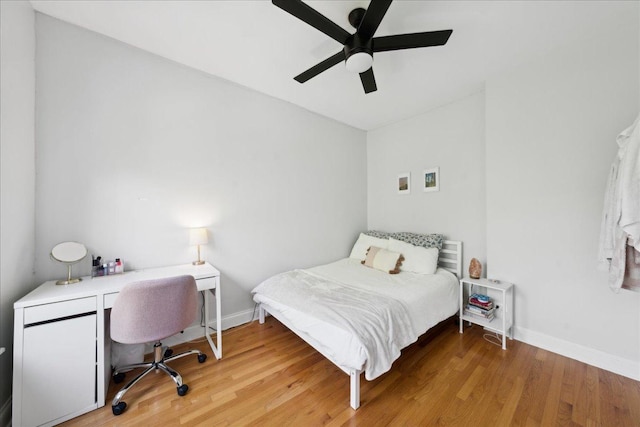 bedroom with baseboards, light wood-style flooring, and a ceiling fan