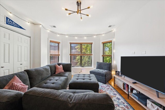 living area with a chandelier, wood finished floors, and rail lighting