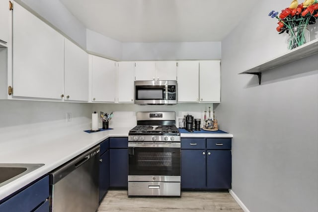 501 Coventry Ln Unit 3, Crystal Lake, IL 60014 - kitchen with stainless steel appliances, blue cabinets, light wood-style floors, light countertops, and white cabinets