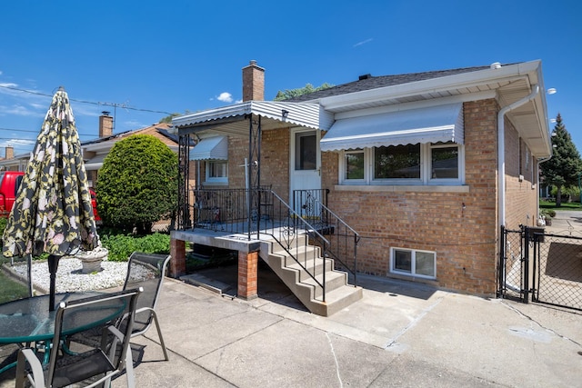 4316 N Sayre Ave, Norridge, IL 60706 - rear view of property with brick siding, a patio area, a gate, and a chimney