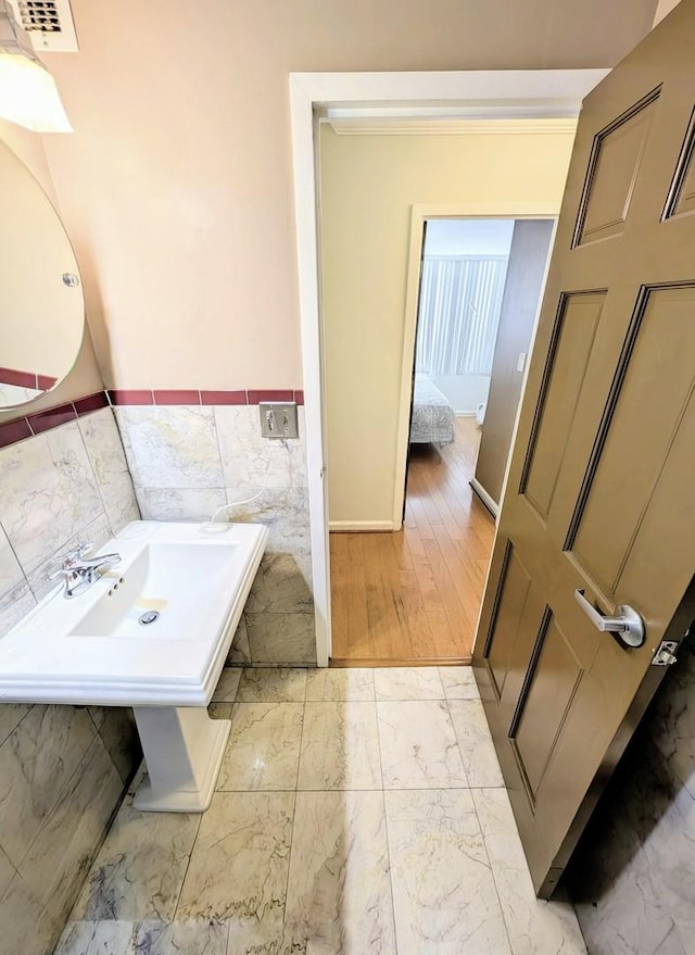 6171 N Sheridan Rd Unit 402, Chicago, IL 60660 - bathroom featuring tile walls, marble finish floors, wainscoting, and baseboards
