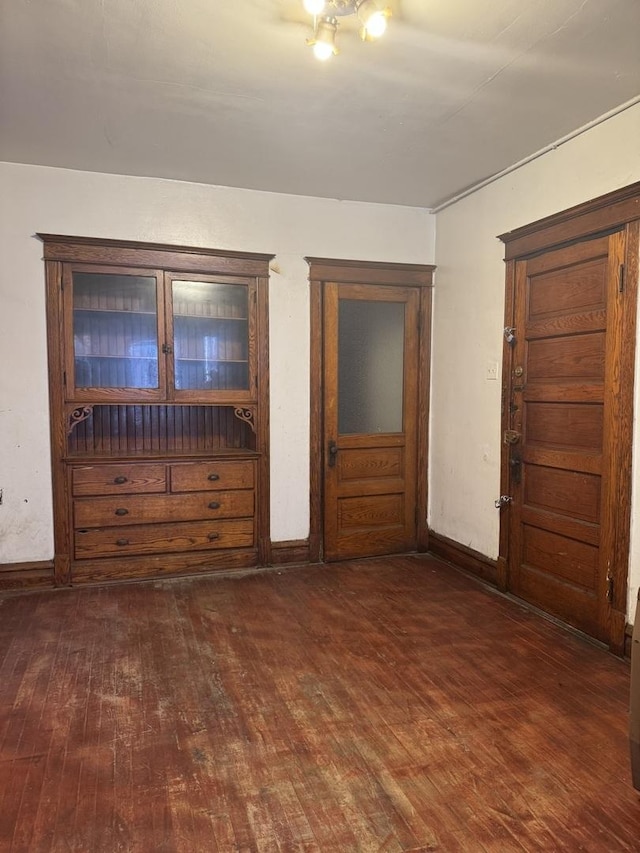 empty room featuring dark wood-type flooring and baseboards