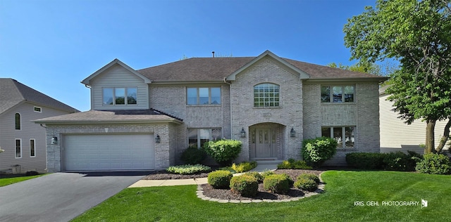 2653 Clara Ave, Aurora, IL 60502 - view of front of home featuring asphalt driveway, a front lawn, a garage, brick siding, and roof with shingles