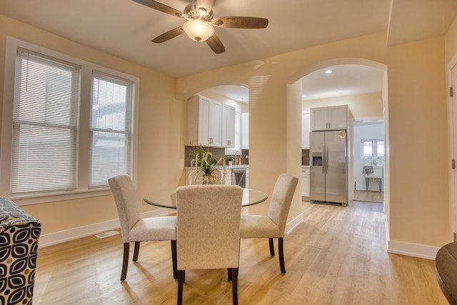 4170 W Cornelia Ave, Chicago, IL 60641 - dining space with light wood-type flooring, arched walkways, plenty of natural light, and ceiling fan