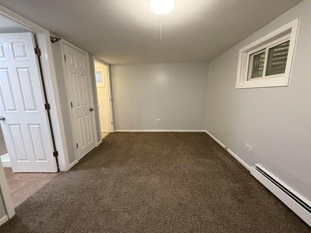 39 King Arthur Ct Unit 10, Northlake, IL 60164 - finished basement with a baseboard heating unit, carpet floors, and baseboards
