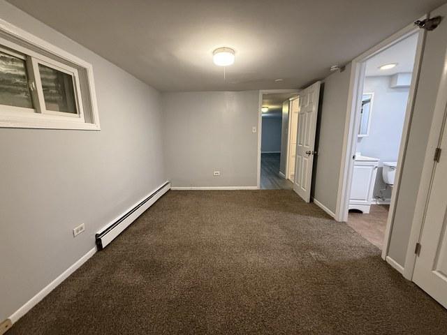 39 King Arthur Ct Unit 10, Northlake, IL 60164 - unfurnished room with baseboard heating, carpet flooring, and baseboards