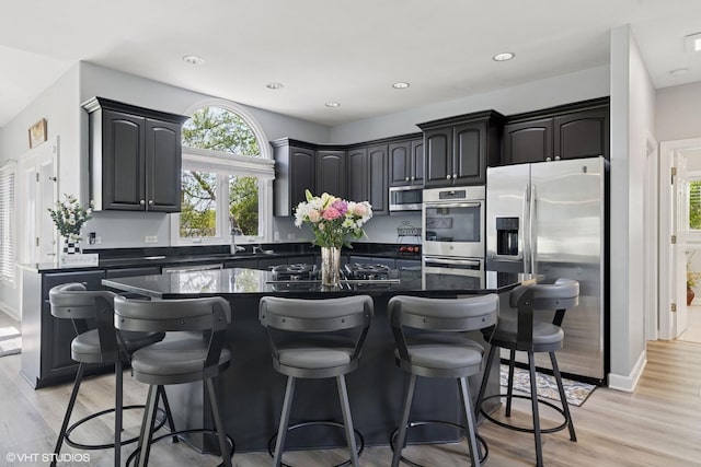 4276 Colton Cir, Naperville, IL 60564 - kitchen with dark countertops, stainless steel appliances, a kitchen island, plenty of natural light, and recessed lighting